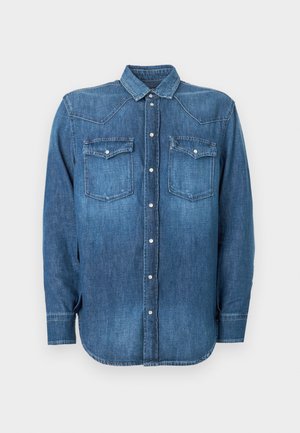 Camicia in denim di blu medio con colletto button-down, due tasche sul petto e maniche lunghe. Presenta cuciture a contrasto e un orlo curvo.