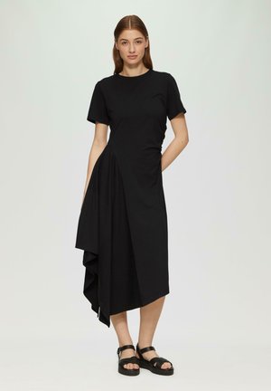Schwarzes Kleid mit kurzen Ärmeln, asymmetrischem Saum und schichtiger Textur. Verfügt über einen runden Ausschnitt und eine seitliche Tasche für zusätzliche Details.