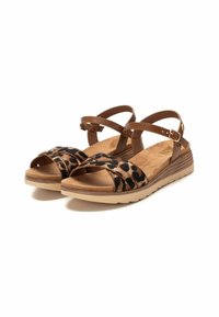 Sandalias marrones con una correa de estampado de leopardo, una plantilla acolchada y una suela flexible de color claro con un tacón bajo en cuña.
