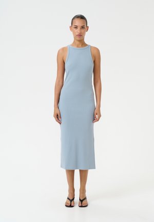 Abito midi senza maniche a costine, di colore azzurro chiaro, con scollatura a girocollo e silhouette aderente, abbinato a infradito nere su uno sfondo neutro.