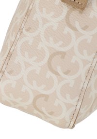 Beige väska med ett tonalt GG-monogrammönster, texturerat material, rena linjer och en liten beigefärgad metalldetalj.