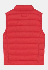 Chaleco acolchado rojo con cuello alto, diseño acolchado horizontal y corte sin mangas. Textura suave con un acabado ligero.