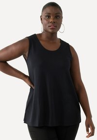 Czarny top bez rękawów z okrągłym dekoltem, o miękkiej fakturze i luźnym kroju, z gładkimi liniami i bez widocznych wzorów czy elementów metalowych.