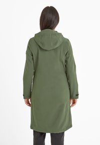 Long green hooded coat with a smooth texture and side pockets, featuring a simple design. Worn over dark pants, viewed from the back.