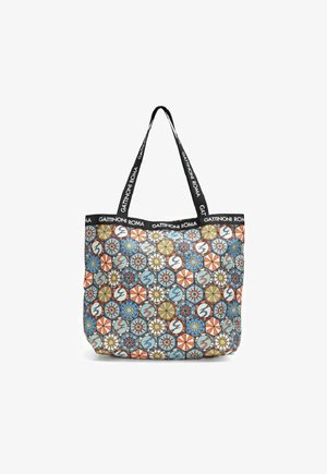 Wzorzysta torba na ramię wykonana z tkaniny z kolorowym wzorem, w tym geometricalne kształty, kwiaty i okrągłe akcenty. Czarną rączkami z logo.