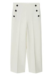 Pantalons larges ivoire avec six grands boutons noirs disposés en deux rangées verticales près des hanches et des plis avant marqués.