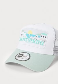 Hvid kasket med en mintgrøn skygge, prydet med en illustration af Santorini. Justerbar mesh bag og logomærke fremhæver designet.