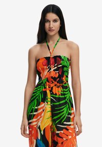 Vestido maxi sin tirantes con un corsé fruncido, que presenta un vibrante estampado tropical en naranja, verde y negro, con un lazo en el cuello tipo halter.