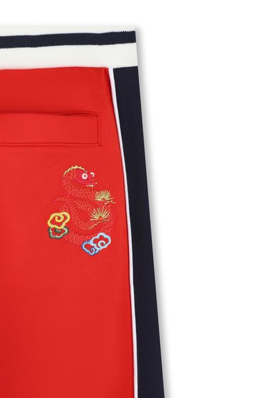 Rode stoffen broek met geborduurd drakenontwerp in tinten van rood, geel en blauw. Donkerblauwe accenten en een detail van een achterzak zijn inbegrepen.