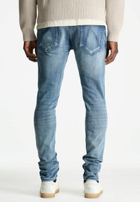 Helle blaue Skinny-Jeans aus Denim, mit klassischem 5-Taschen-Design und sichtbaren Nähten auf den Gesäßtaschen.