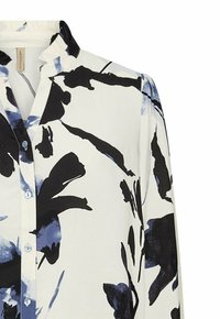 Witte blouse met grote abstracte zwarte en blauwe bloemenpatronen, knoopsluiting aan de voorkant en een subtiele ruches aan de kraag.