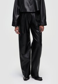 Zwarte leren broek met wijde pijpen, een gladde textuur en een hoge taille. Het ontwerp heeft plooien en wordt gecombineerd met een cropped top.