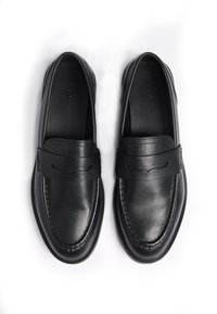 Sorte læder loafers med en glat finish, syede detaljer og en enkel rem over vristen. Flad sål, ingen synlige metaldele.