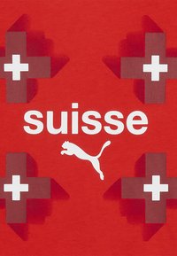Rød t-shirt med hvid tekst "suisse" og et hvidt Puma-logo, med fire 3D røde og hvide schweiziske krydsdesign som accenter.