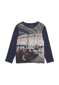 Langärmliges T-Shirt mit Grafik eines roten Traktors und einer Kuh vor einer Scheunenruine. Marineblaue Grundfarbe, Baumwollmischung, weiche Textur.