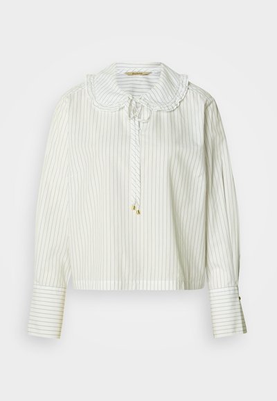 Blouse rayée blanche avec un col festonné, des manches longues et une fermeture à nouer. Dotée de détails dorés et d'une coupe décontractée.