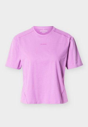 Rövid ujjú, kerek nyakú lila Salomon póló, amelyen finom logó található a mellkas közepén, kifejezetten aktív viseletre tervezték.