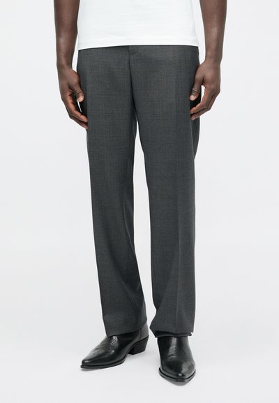 Szare, dopasowane spodnie o fakturowanym wykończeniu, z prostym przodem i prostymi nogawkami, zestawione z czarnymi skórzanymi butami.