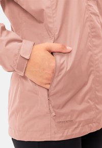 Light pink jacket made of textured fabric, featuring a zippered pocket and adjustable cuff. Logo "CEPLEX ACTIVE" on the bottom edge.