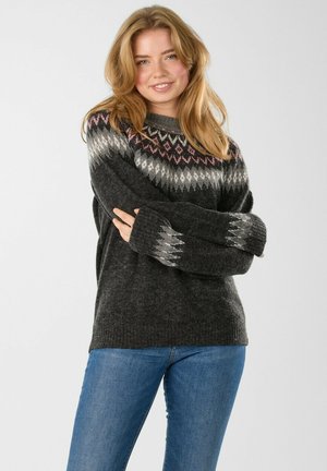 Gray knitted sweater with a fair isle pattern in black, white, and pink. Features long sleeves and a round neckline. Paired with blue jeans.