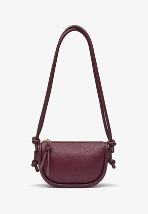 Liten vinröd lädercrossbody-väska med långa knutna remmar och ett blixtlås upptill.