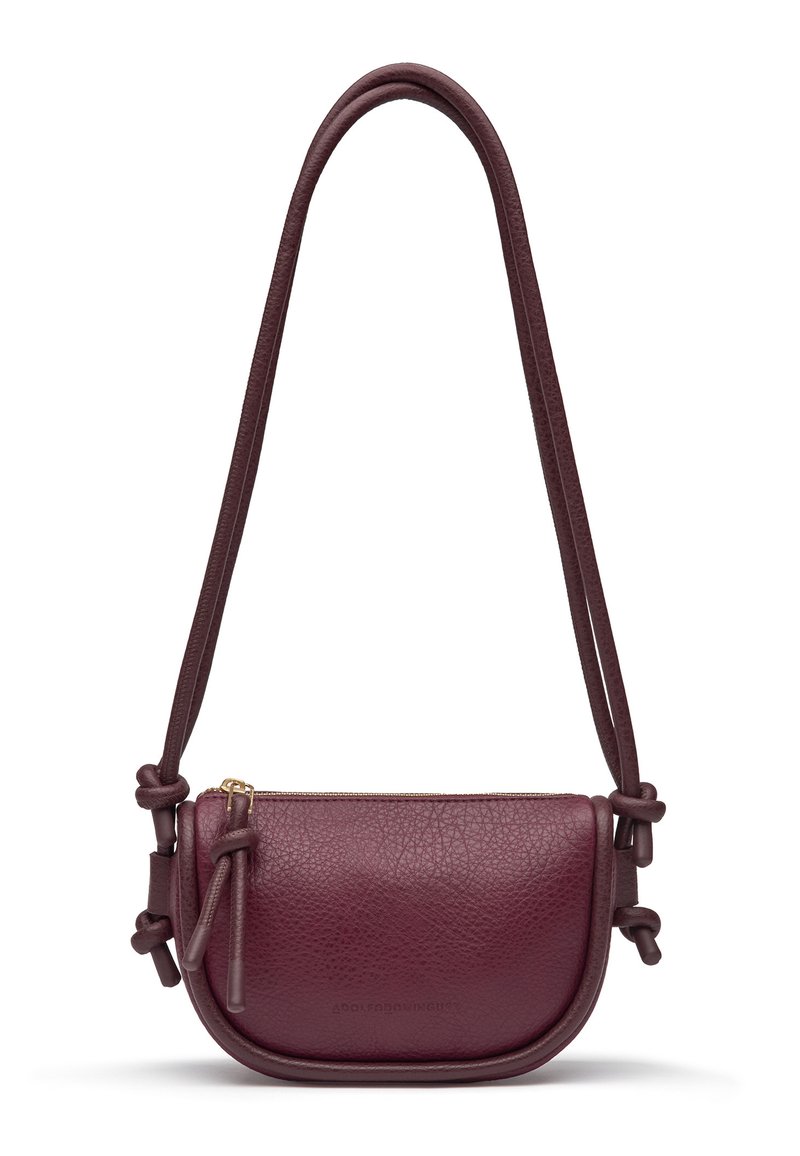 Petite sac en cuir bordeaux porté travers avec de longues bandoulières nouées et une fermeture éclair en haut.