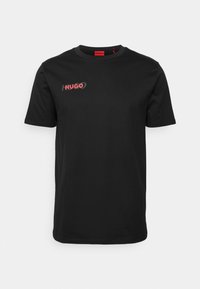 Černé tričko s krátkým rukávem a kulatým výstřihem, s červeným logem Hugo tištěným na levé hrudi.