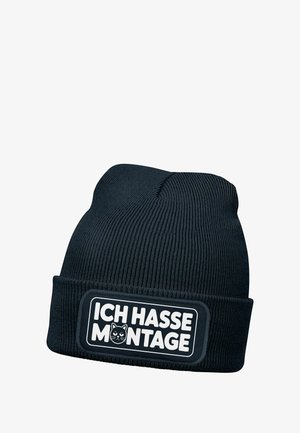 Black knitted beanie with ribbed texture, featuring a rectangular patch with "ICH HASSE MONTAGE" and a cat graphic in white.