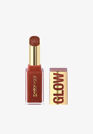 Rossetto in una tonalità rossa scintillante con tubo dorato e base rettangolare rossa scintillante, accanto al suo tappo dorato con etichetta "GLOW".