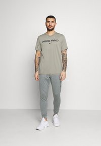 Nike Performance M NK DRY PANT HPR DRY LT YOGA - Calças de fato de treino - smoke grey/iron grey/black