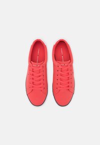 Röda duk sneakers med snörning, rund tå och kontrasterande svart sula med varumärkeslogotyp på innersulan.