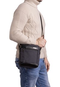 Borsa a tracolla nera e grigia con tasca frontale con zip e cintura regolabile, realizzata in tessuto testurizzato per una maggiore durata.