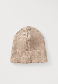 Beež kahvkudumine talvebeanie koos volditud äärtega, eksponeeritud tasapinnal valge tausta peal.