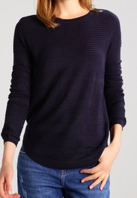 Mörk marinblå strukturstickad tröja med rundad halsringning, långa ärmar och en avslappnad passform, med horisontella ränder och ett mjukt tyg.