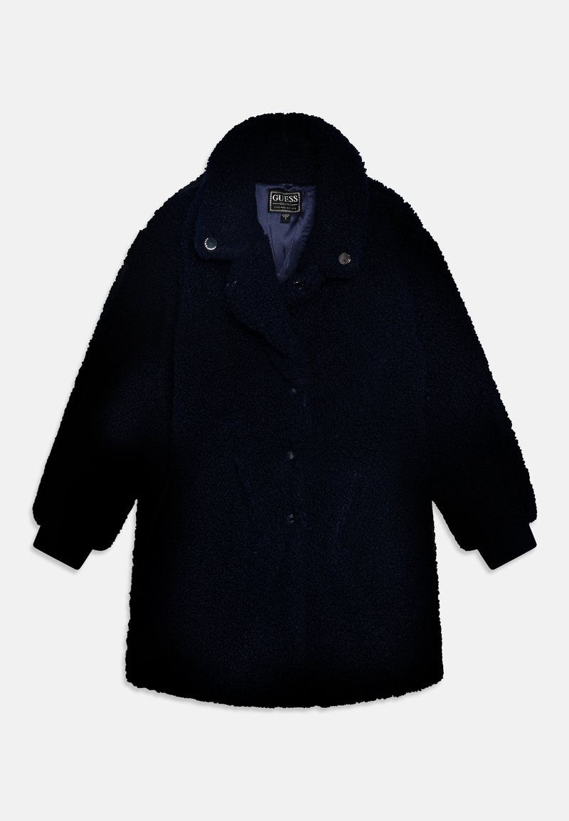 Manteau teddy noir avec col large et boutons-pression, manches longues et tissu doux texturé, de la marque Guess.