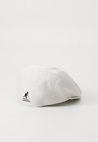 Beret alb cu tricot fin, având un mic logo negru Kangol pe lateral. Formă rotunjită cu detalii de cusătură subtile.