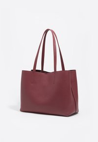 Bordowa torba na ramię ze skóry o gładkiej fakturze, minimalistycznym designie, wydłużonych uchwytach i otwartym wnętrzu. Bez widocznych elementów metalowych ani wzorów.