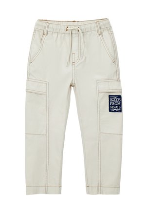 Pantalones cargo beige para niños con cintura elástica, cordón, bolsillos laterales y una etiqueta en la pierna derecha que dice "HOLA DESDE SEÚL."