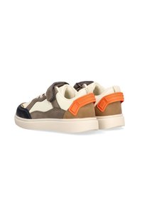 Zapatillas marrones y crema con puntera negra y acentos naranjas en el talón. Fabricadas con materiales mixtos, incluyen una correa de velcro y detalles texturizados.