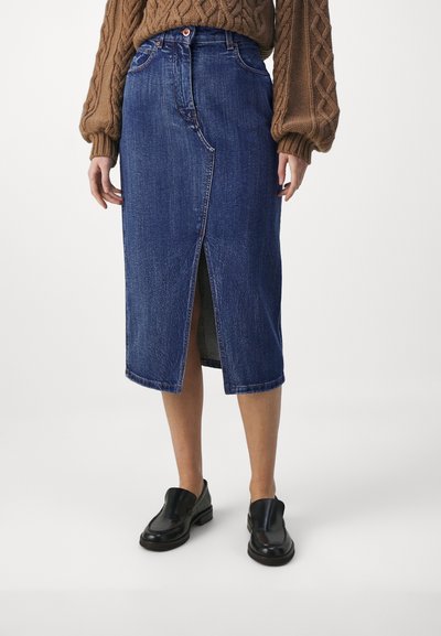 Denim midi skjørt, mørk blå, frontsplitt, middels høy midje med knappelukking, paret med svarte slip-on sko. Teksturert stoff.