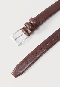 Καφέ δερμάτινη ζώνη με ασημένια ορθογώνια αγκράφα και πολλαπλές τρύπες ρύθμισης σε λευκό φόντο.