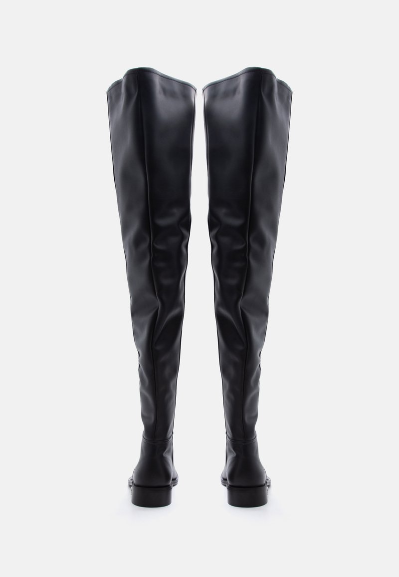 Tall black leather boots standing upright, viewed from the back, showing smooth texture and slight creases along the shaft.
