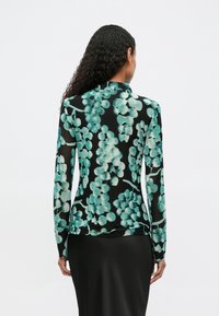Blusa preta de manga longa com padrão floral turquesa. Material transparente, design ajustado, com gola alta e textura subtil.