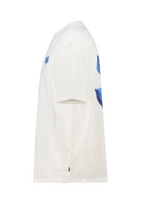 Camiseta blanca de manga corta con diseños florales azules en el lado izquierdo del pecho y en el lado derecho. Fabricada en algodón suave con un corte relajado.