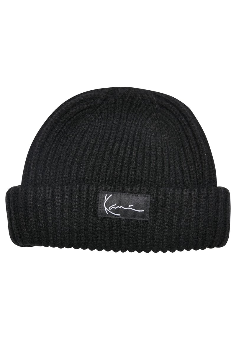 Beanie tricotat negru cu textură rib. Prezintă un tiv răsucit și o etichetă țesută rectangulară care afișează o semnătură albă.