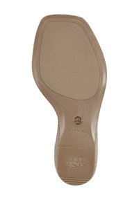 Semelle en caoutchouc brun au fini texturé, arborant des logos en relief et des détails de taille. Forme contournée pour un soutien et une adhérence au niveau du pied.