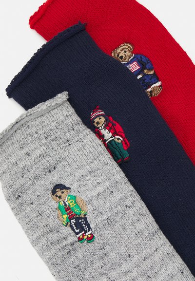 Three knit scarves in red, navy, and grey; each features embroidered teddy bears in various outfits and vibrant colors on the front.