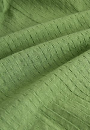 Vihreä tekstuuri, joka näyttää hieman ryppyiseltä, sisältää epätasaisen pinta-kuvion ja pehmeän, mattaisen pinnan.