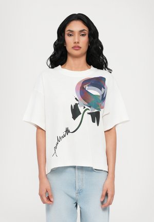 Weißes T-Shirt mit kurzen Ärmeln, das ein farbenfrohes abstraktes Blumenmuster und eine Signatur aufweist. Weicher Baumwollstoff mit bequemem Schnitt.