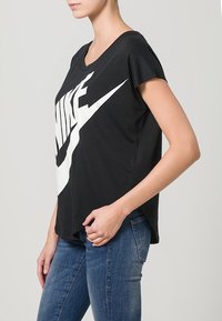 Zwarte Nike t-shirt met korte mouwen, voorzien van een groot wit swoosh-logo. Gemaakt van zachte stof, met een losse, relaxte pasvorm.